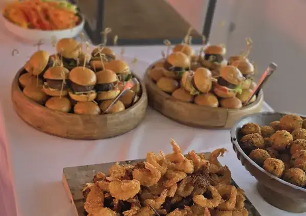 Sliders, tempura prawns and arancini on a sharing table
